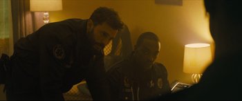 Movie still from “Synchronic” (2019), directed by Justin Benson – Two police officers looking at a computer screen; Medium shot, Over the shoulder angle