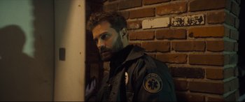 Movie still from “Synchronic” (2019), directed by Justin Benson – A man in a black jacket standing in front of a brick wall; Close Up shot, Over the shoulder angle