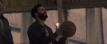 Movie still from “Synchronic” (2019), directed by Justin Benson – A man holding a basketball in his hands; Close Up shot, Low angle