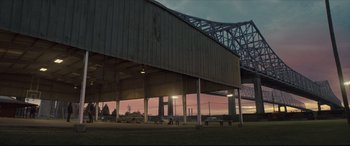 Movie still from “Synchronic” (2019), directed by Justin Benson – A view of a bridge from under a building; Extreme Wide shot, Low angle