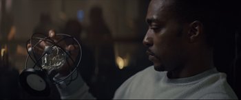 Movie still from “Synchronic” (2019), directed by Justin Benson – A man sitting in front of a mirror while looking at the camera; Close Up shot, Low angle