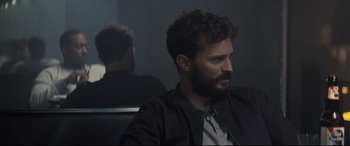 Movie still from “Synchronic” (2019), directed by Justin Benson – A man sitting in front of a mirror in a dark room; Close Up shot, Over the shoulder angle