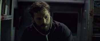 Movie still from “Synchronic” (2019), directed by Justin Benson – A man with a beard is listening to music; Close Up shot, Over the shoulder angle