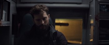 Movie still from “Synchronic” (2019), directed by Justin Benson – A man sitting in a chair looking down at the ground; Close Up shot, Over the shoulder angle