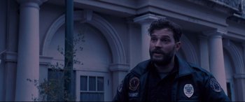 Movie still from “Synchronic” (2019), directed by Justin Benson – A man with a beard is standing in front of a building; Close Up shot, Over the shoulder angle