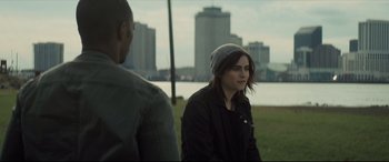 Movie still from “Synchronic” (2019), directed by Justin Benson – A woman wearing a hat and a black jacket is sitting next to a man; Close Up shot, Over the shoulder angle