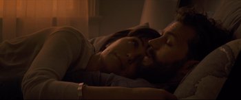 Movie still from “Synchronic” (2019), directed by Justin Benson – A man and a woman laying in a bed together; Close Up shot, Overhead angle