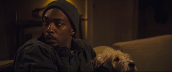 Movie still from “Synchronic” (2019), directed by Justin Benson – A man and a dog laying on a couch; Close Up shot, Over the shoulder angle