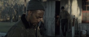 Movie still from “Synchronic” (2019), directed by Justin Benson – A man in a hat is looking down at his face; Close Up shot, Over the shoulder angle