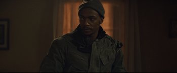 Movie still from “Synchronic” (2019), directed by Justin Benson – A man wearing a green jacket and a hat; Close Up shot, Over the shoulder angle