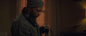 Movie still from “Synchronic” (2019), directed by Justin Benson – A man in a hat is holding a camera; Close Up shot, Over the shoulder angle