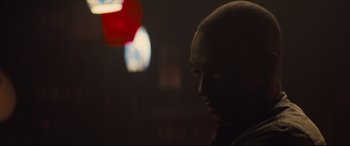 Movie still from “Synchronic” (2019), directed by Justin Benson – A man with a bald head is in the dark; Close Up shot, Over the shoulder angle