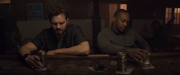 Movie still from “Synchronic” (2019), directed by Justin Benson – A couple of men sitting at a table with drinks; Medium shot, High angle