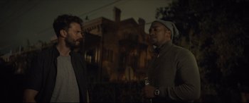 Movie still from “Synchronic” (2019), directed by Justin Benson – Two men standing next to each other in front of a building; Medium shot, Over the shoulder angle