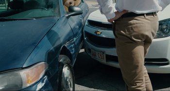 Movie still from “Ted” (2012), directed by Seth MacFarlane – A man standing next to a car with a teddy bear in it's trunk; Medium shot, Over the shoulder angle