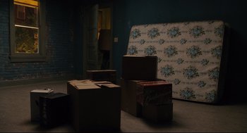 Movie still from “Ted” (2012), directed by Seth MacFarlane – A room filled with boxes and a person standing in a doorway; Wide shot, High angle