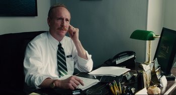 Movie still from “Ted” (2012), directed by Seth MacFarlane – A man sitting at a desk in front of a phone; Close Up shot, Over the shoulder angle