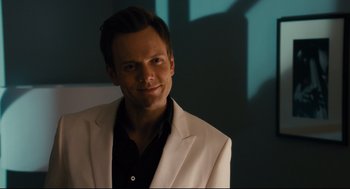 Movie still from “Ted” (2012), directed by Seth MacFarlane – A man in a white jacket smiling for the camera; Close Up shot, Over the shoulder angle