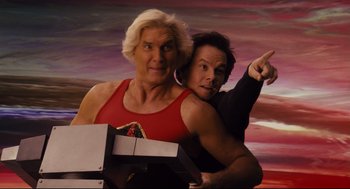 Movie still from “Ted” (2012), directed by Seth MacFarlane – A man and a woman are posing for a picture together; Medium shot, Low angle
