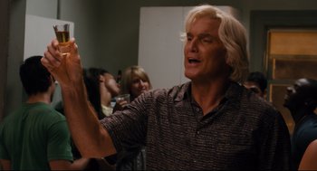 Movie still from “Ted” (2012), directed by Seth MacFarlane – A man holding up a cell phone in front of a group of people; Close Up shot, Low angle