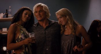 Movie still from “Ted” (2012), directed by Seth MacFarlane – A man and two women posing for a picture; Medium shot, Low angle