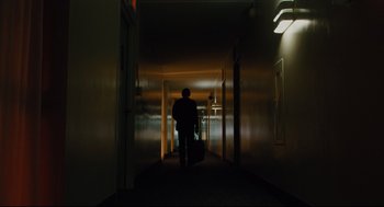 Movie still from “Ted” (2012), directed by Seth MacFarlane – A person walking down a hallway with a suitcase; Wide shot, Low angle