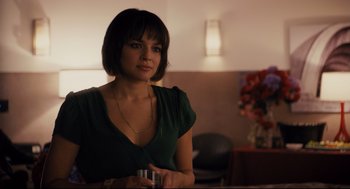 Movie still from “Ted” (2012), directed by Seth MacFarlane – A woman sitting in front of a table holding a drink; Close Up shot, Over the shoulder angle