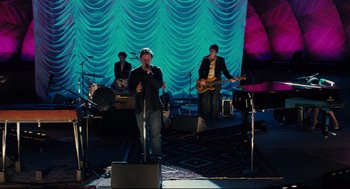 Movie still from “Ted” (2012), directed by Seth MacFarlane – A group of men performing on a stage; Wide shot, High angle