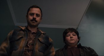 Movie still from “Ted” (2012), directed by Seth MacFarlane – A man and a boy standing next to each other in a room; Medium shot, Low angle