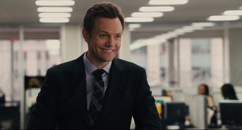 Movie still from “Ted” (2012), directed by Seth MacFarlane – A man wearing a suit and tie smiling for the camera; Close Up shot, Over the shoulder angle