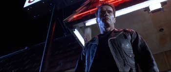 Movie still from “Terminator 2: Judgment Day” (1991), directed by James Cameron – A man standing in front of a neon sign; Medium shot, Low angle