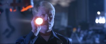 Movie still from “Terminator 2: Judgment Day” (1991), directed by James Cameron – A man holding a flashlight in a dark room; Close Up shot, Low angle
