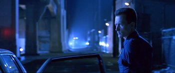 Movie still from “Terminator 2: Judgment Day” (1991), directed by James Cameron – A man standing next to a car on a street at night; Close Up shot, Low angle