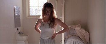 Movie still from “Terminator 2: Judgment Day” (1991), directed by James Cameron – A woman standing in front of a bed in a room; Medium shot, Low angle