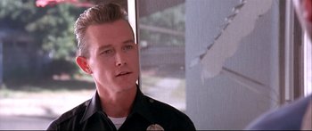 Movie still from “Terminator 2: Judgment Day” (1991), directed by James Cameron – A man in a police uniform looking to his left; Close Up shot, Low angle