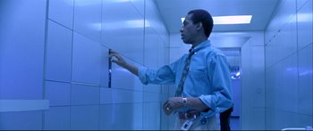 Movie still from “Terminator 2: Judgment Day” (1991), directed by James Cameron – A man in a blue dress shirt and a tie is in a bathroom; Medium shot, Low angle