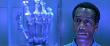 Movie still from “Terminator 2: Judgment Day” (1991), directed by James Cameron – A person in a blue room; Close Up shot, Over the shoulder angle