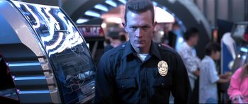 Movie still from “Terminator 2: Judgment Day” (1991), directed by James Cameron – A man in a police uniform standing next to a car; Close Up shot, Low angle