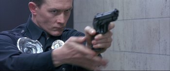 Movie still from “Terminator 2: Judgment Day” (1991), directed by James Cameron – A man holding a gun in his hand; Close Up shot, Low angle