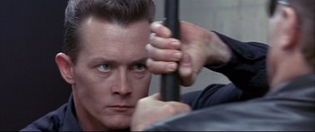 Movie still from “Terminator 2: Judgment Day” (1991), directed by James Cameron – A person holding onto a pole; Close Up shot, Low angle