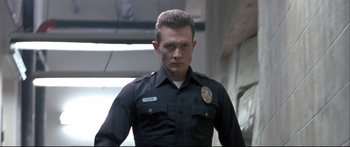 Movie still from “Terminator 2: Judgment Day” (1991), directed by James Cameron – A man in a police uniform standing in front of stairs; Close Up shot, Low angle