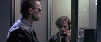 Movie still from “Terminator 2: Judgment Day” (1991), directed by James Cameron – A man and a woman are talking on a phone; Close Up shot, Low angle
