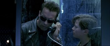 Movie still from “Terminator 2: Judgment Day” (1991), directed by James Cameron – A man talking on a phone next to a woman; Close Up shot, Low angle