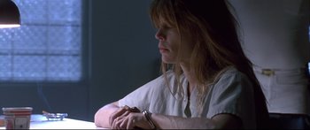Movie still from “Terminator 2: Judgment Day” (1991), directed by James Cameron – A woman sitting at a table with her hands folded together; Close Up shot, Low angle