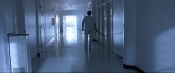 Movie still from “Terminator 2: Judgment Day” (1991), directed by James Cameron – A man walking down a hallway with a mop in his hand; Wide shot, Low angle