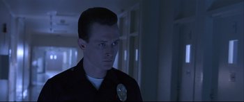 Movie still from “Terminator 2: Judgment Day” (1991), directed by James Cameron – A man in a police uniform looking to his left; Close Up shot, Low angle