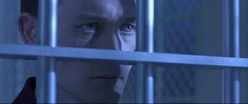 Movie still from “Terminator 2: Judgment Day” (1991), directed by James Cameron – A person looking through a metal fence; Close Up shot, Over the shoulder angle