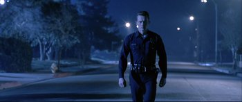 Movie still from “Terminator 2: Judgment Day” (1991), directed by James Cameron – A police officer walking on a street at night; Medium shot, Low angle