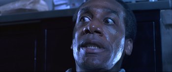 Movie still from “Terminator 2: Judgment Day” (1991), directed by James Cameron – A man's face in a dark room; Close Up shot, Low angle