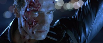 Movie still from “Terminator 2: Judgment Day” (1991), directed by James Cameron – A man's face with blood on his face; Close Up shot, Over the shoulder angle